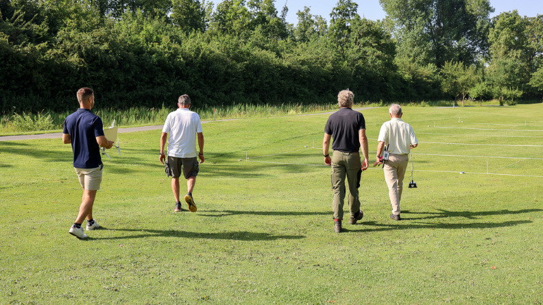 Four members of the trial team walking among marked fairway plots at Golfcentrum de Batouwe.