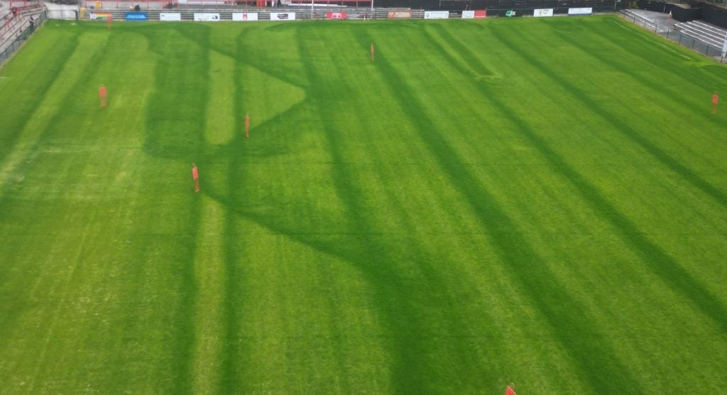 Campo di calcio dove il concime è stato applicato male a causa di un errore di calibrazione dello spandiconcime e di errore nell'andatura di spargimento